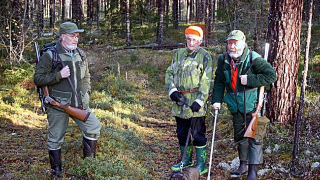 Familjen Johansson i N&aring;s i Dalarna. Fr&aring;n v&auml;nster Sven, Aina och sonen Torsten, samt taxen Pia, f&ouml;rst&aring;s. Nu &auml;r det r&aring;djursjakt och mor Aina bandar med Pia.