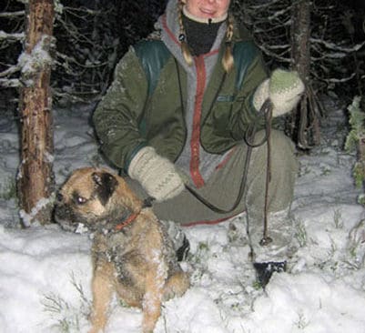 Janet Persson från Särna med borderterriern Orwar, ivrigt väntande vid ett gryt.